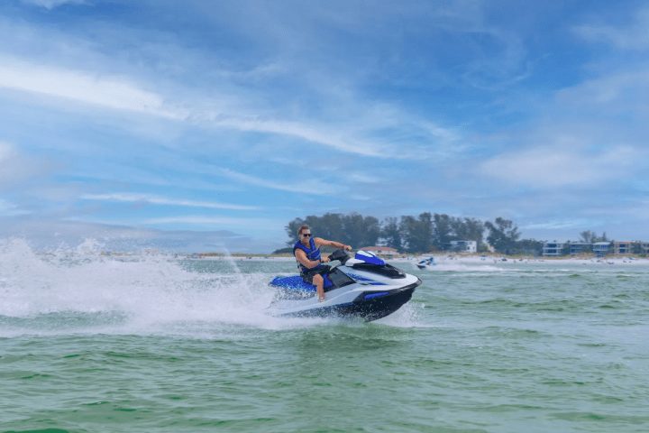 a man riding on the back of a boat in a body of water