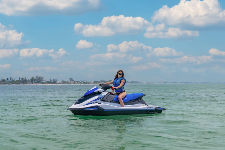 a man riding on the back of a boat in a body of water